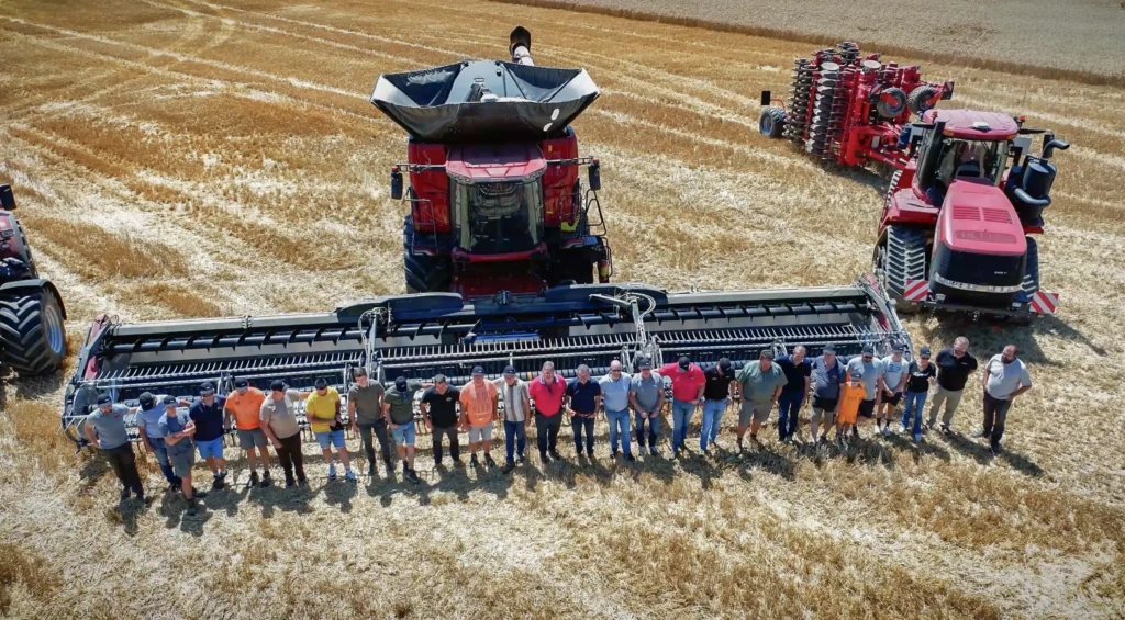 Vue aérienne d’une démonstration agricole Case IH dans un champ de céréales lors de l'Axial Tour 2025 : une moissonneuse-batteuse Axial-Flow 10 entourée d’agriculteurs, avec plusieurs machines Case IH en arrière-plan.